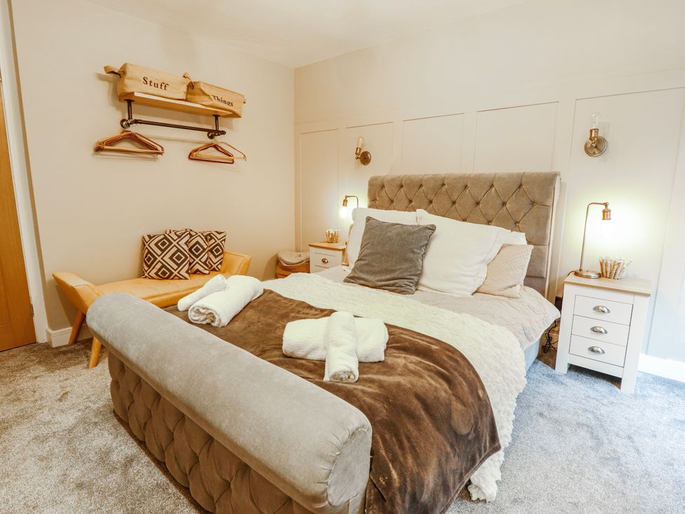 A bedroom with a bed and bedside tables at Hafod Y Bryn Harlech