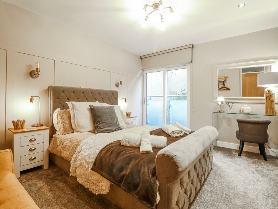 A bedroom with a bed and nightstand at Hafod Y Bryn in Harlech