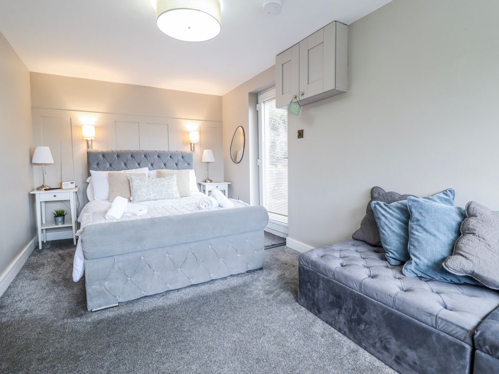 A bedroom with a bed and sofa at Hafod Y Bryn in Harlech