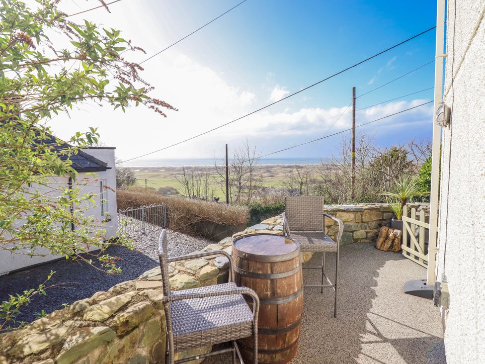 An outdoor area with chairs and a barrel at Hafod Y Bryn in Harlech