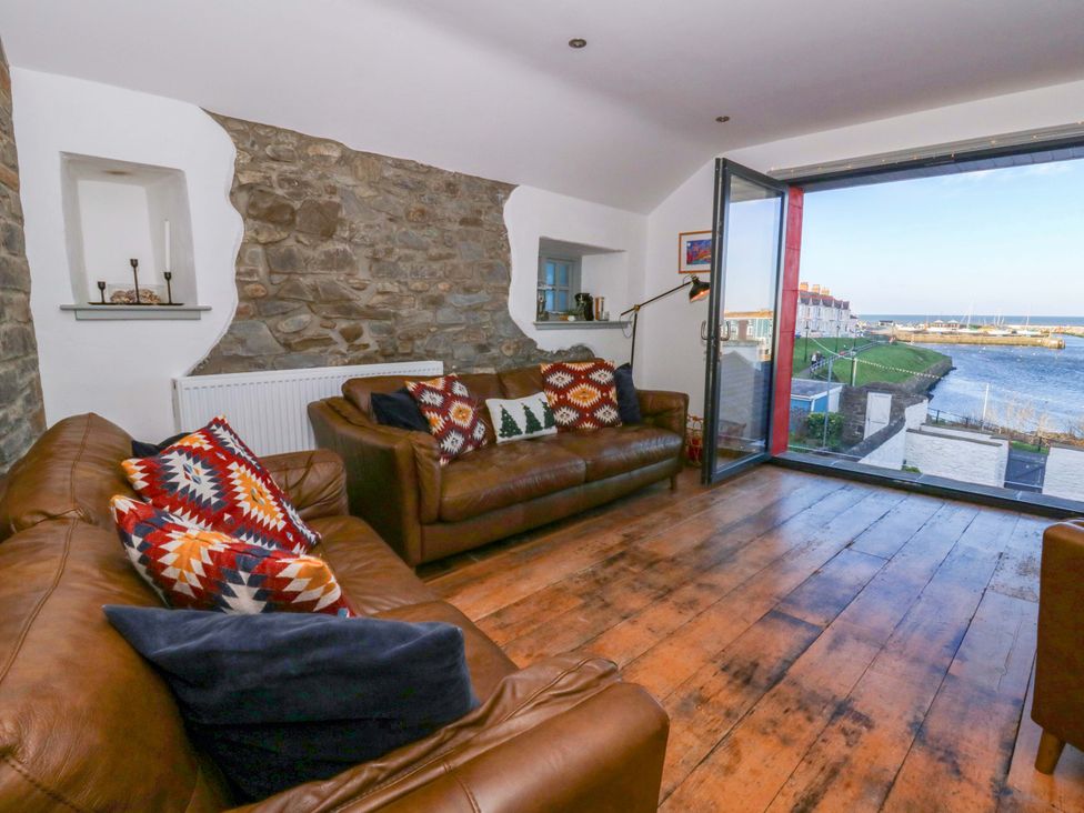 A living room with sofas and a large window at Island House in Aberaeron