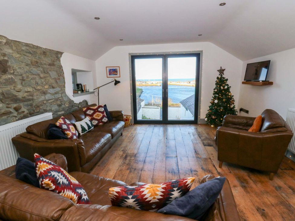 A living room with a view of the water at Island House in Aberaeron