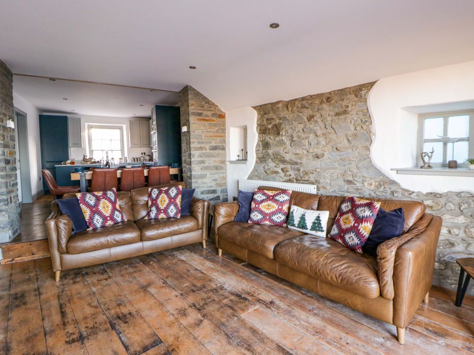A living room with leather sofas and a dining area at Island House in Aberaeron