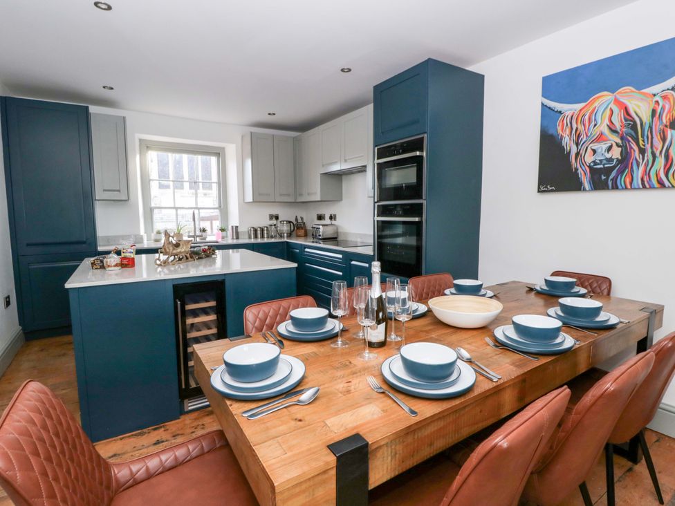 A kitchen with a dining table set at Island House Aberaeron