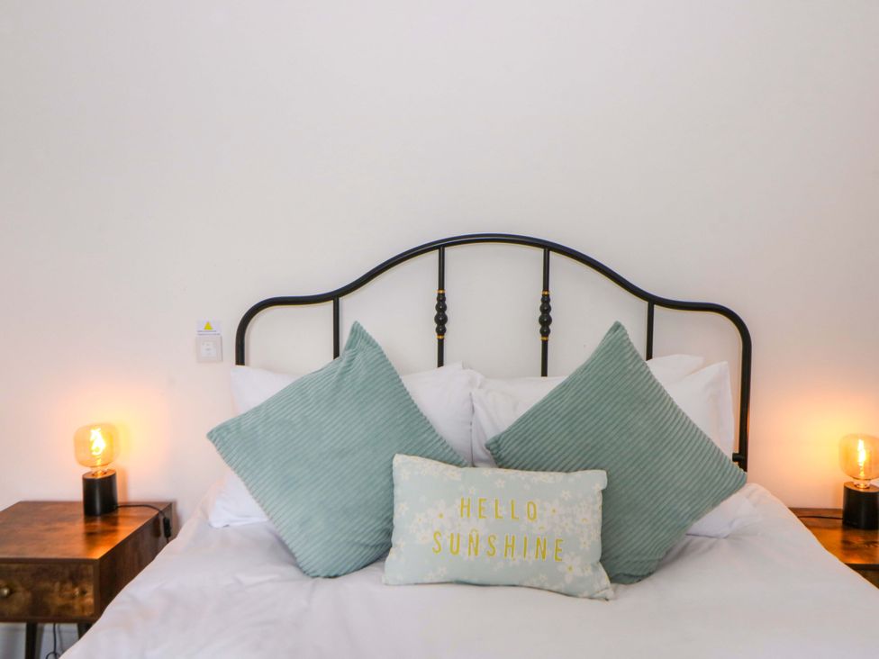 A bedroom with a bed and decorative pillows at Island House in Aberaeron