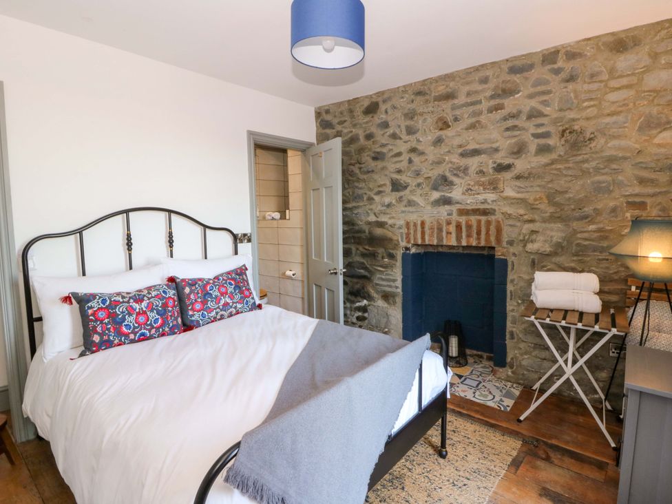 A bedroom with a bed and fireplace at Island House Aberaeron