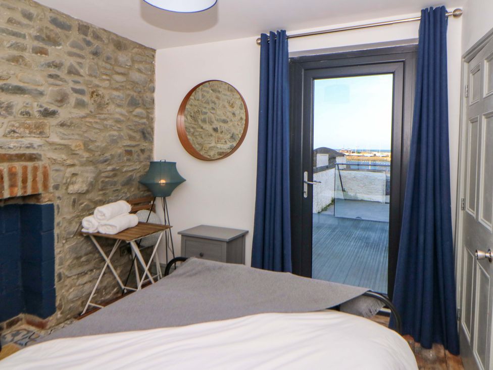 A bedroom with a bed and a mirror at Island House in Aberaeron