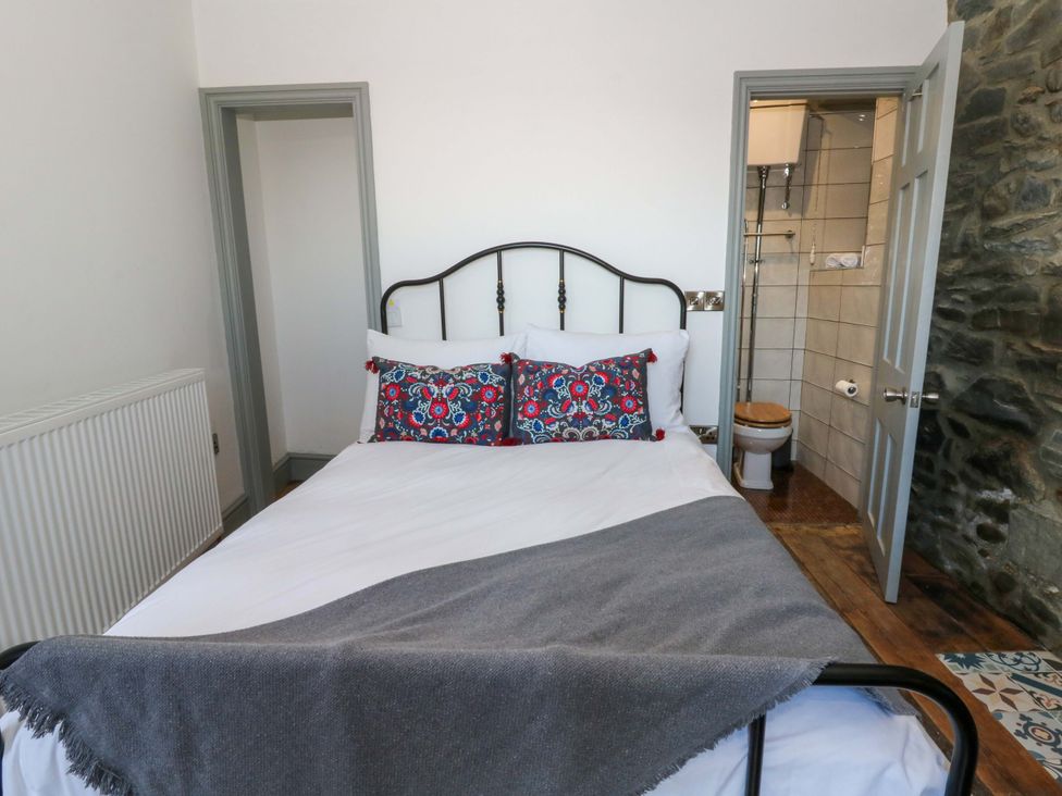 A bedroom with a bed and an ensuite bathroom at Island House Aberaeron