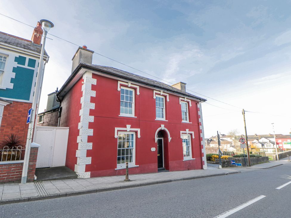 A red building with windows and a door at Island House in Aberaeron
