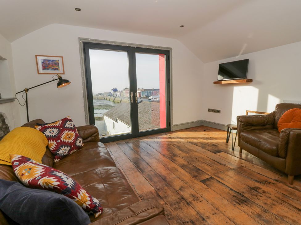 A living room with a sofa and TV at Island House in Aberaeron