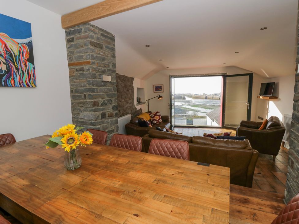 A living room with a sofa and a dining table at Island House in Aberaeron