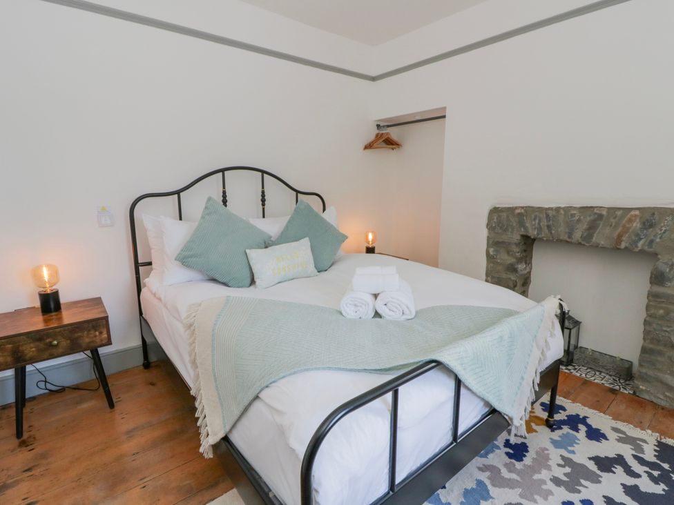 A bedroom with a bed and nightstand at Island House in Aberaeron