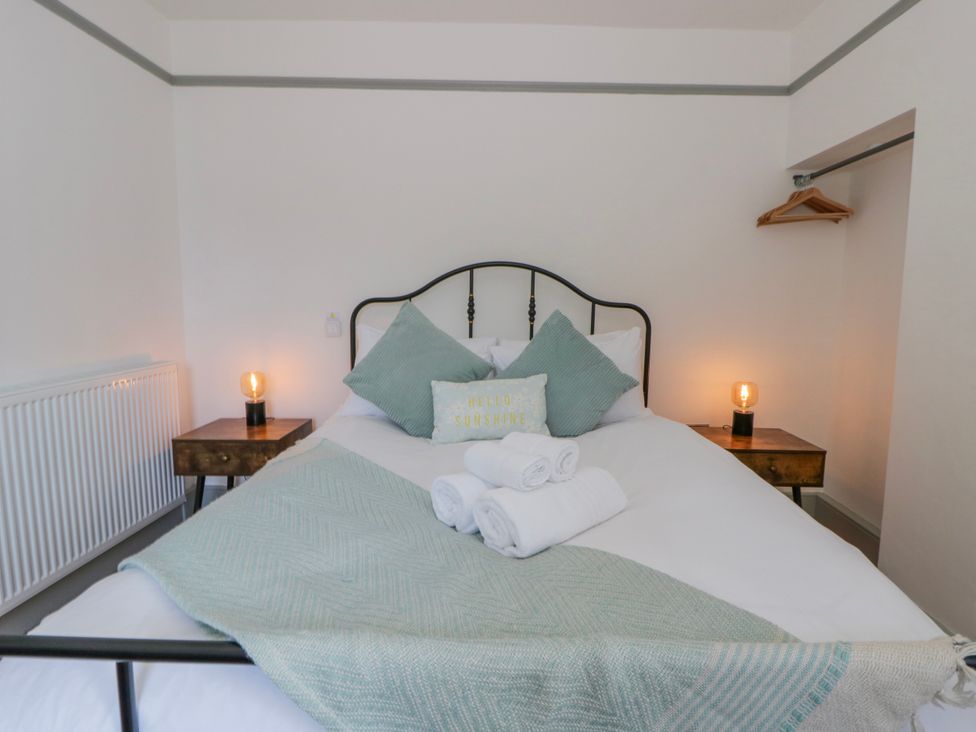 A bedroom with a bed and bedside tables at Island House Aberaeron
