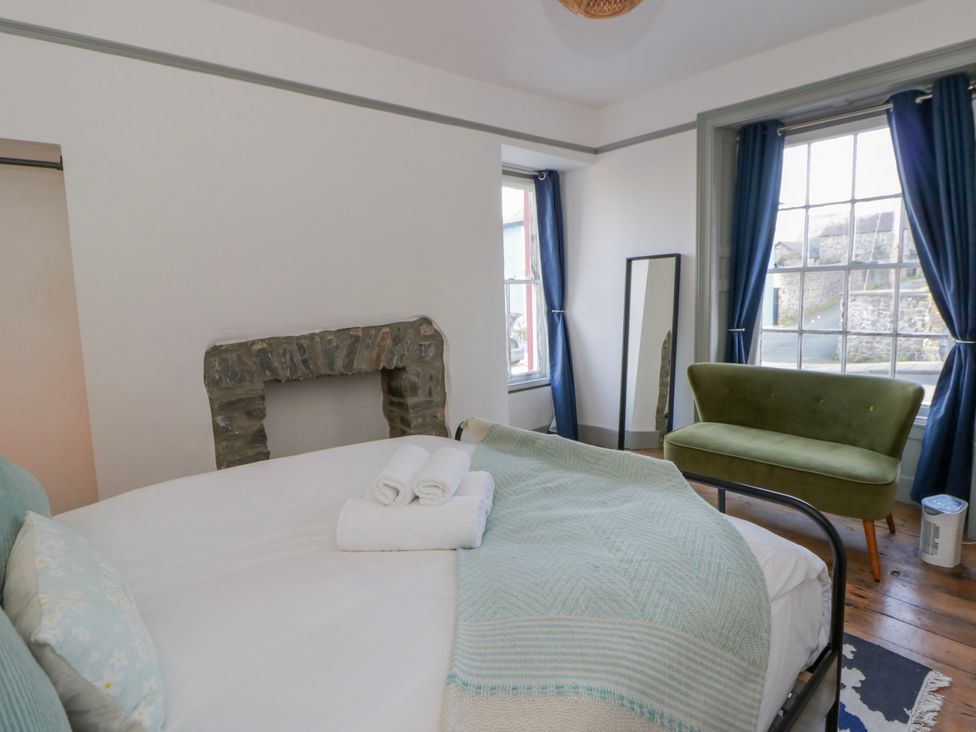 A bedroom with a bed and towels at Island House Aberaeron