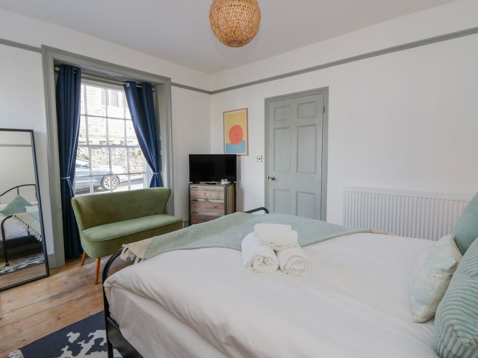 A bedroom with a bed and a chair at Island House in Aberaeron