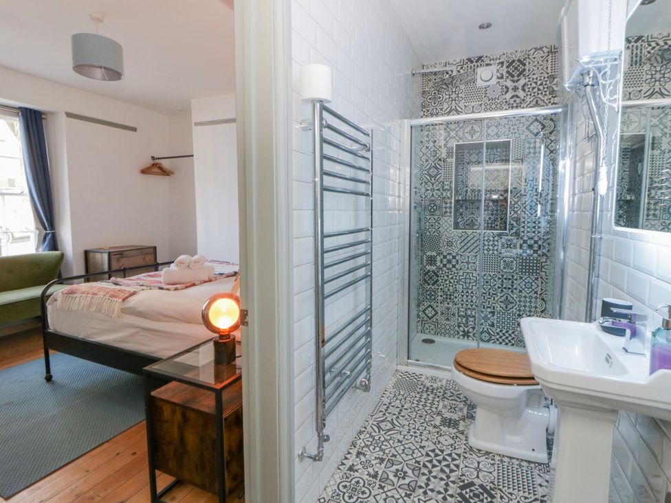 A bathroom with a shower and toilet adjoining a bedroom at Island House in Aberaeron