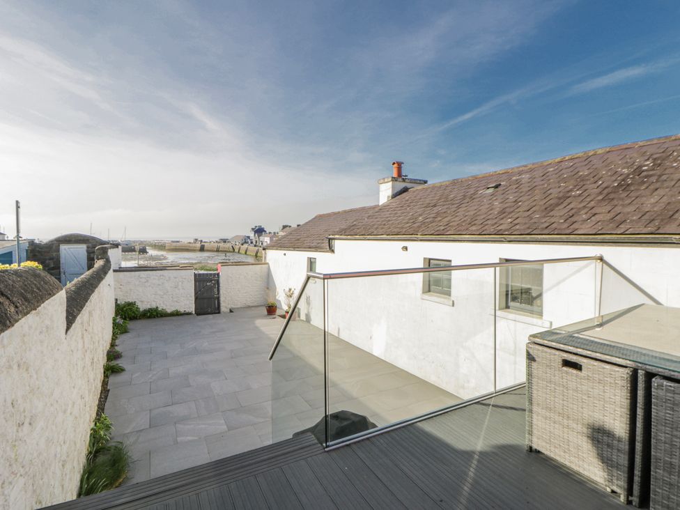 An outdoor space with a glass railing and paved area at Island House in Aberaeron