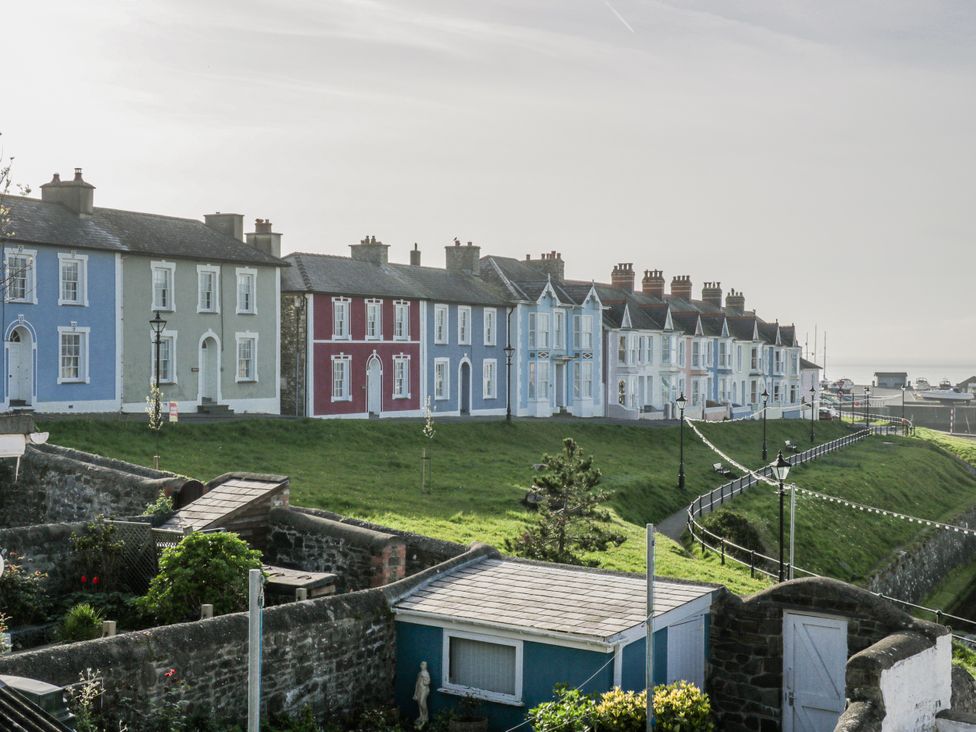 A row of colorful houses with greenery at Island House in Aberaeron