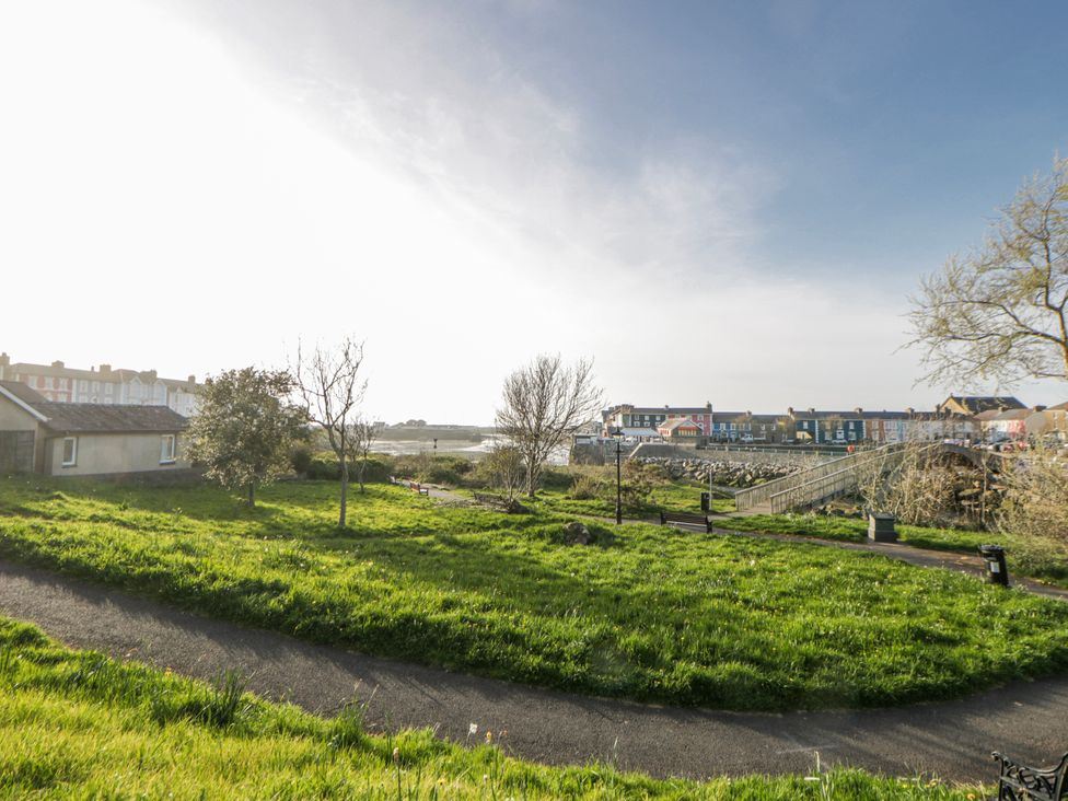 A view of the grass and trees with houses and a bridge at Island House Aberaeron