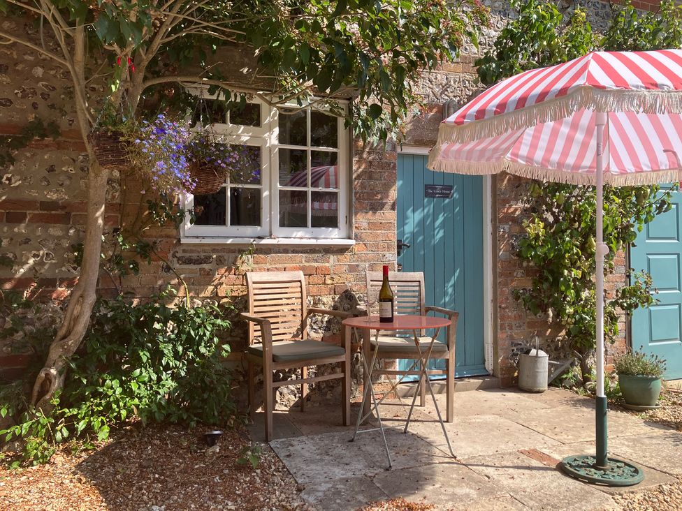 An outdoor area with a table and chairs at The Coach House - Trinity Lodge in Godmanstone near Cerne Abbas