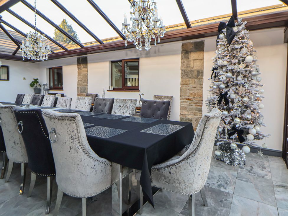 A dining room with a table and chairs at Brookway Lodge in Caerwys