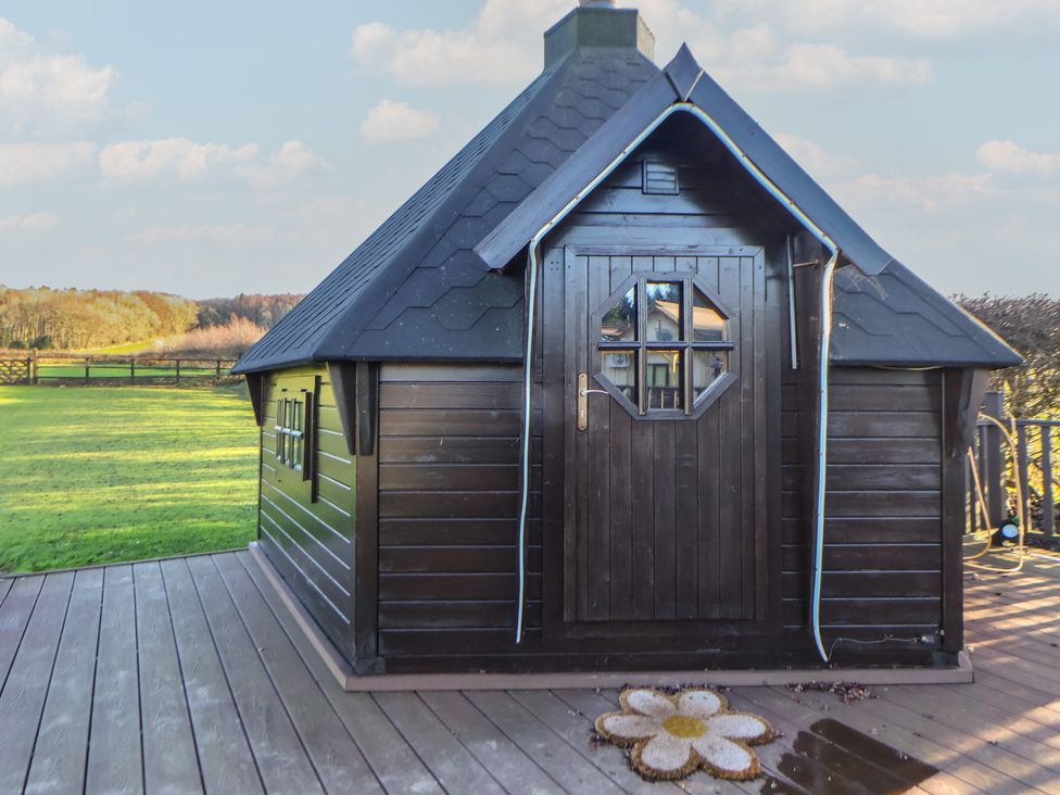A garden shed with wooden deck at Brookway Lodge Caerwys