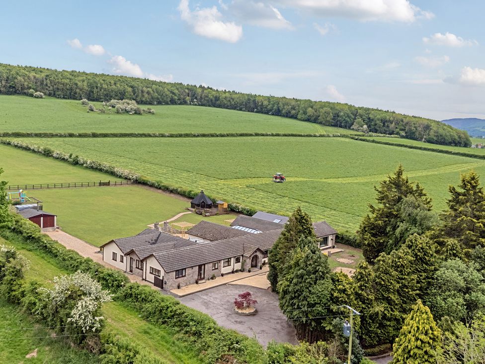 An outdoor view of a house and field at Brookway Lodge in Caerwys