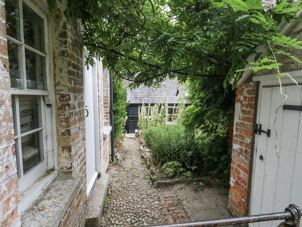 An outdoor pathway with plants and a shed at Chenies in Osmington Mills, near Preston