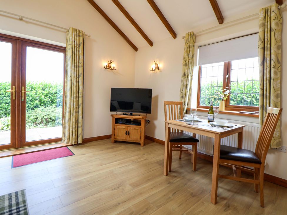 A dining room with a table and chairs at The Brambles in Holt, North Wales