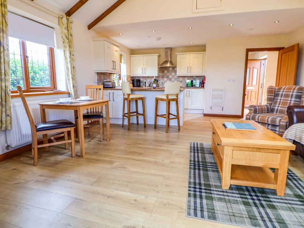A dining room with a table and chairs at The Brambles in Holt, North Wales