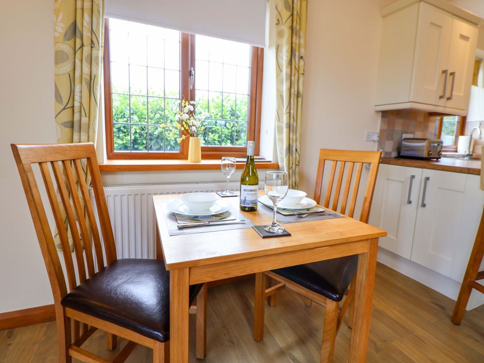 A dining room with a table set for two at The Brambles in Holt, North Wales