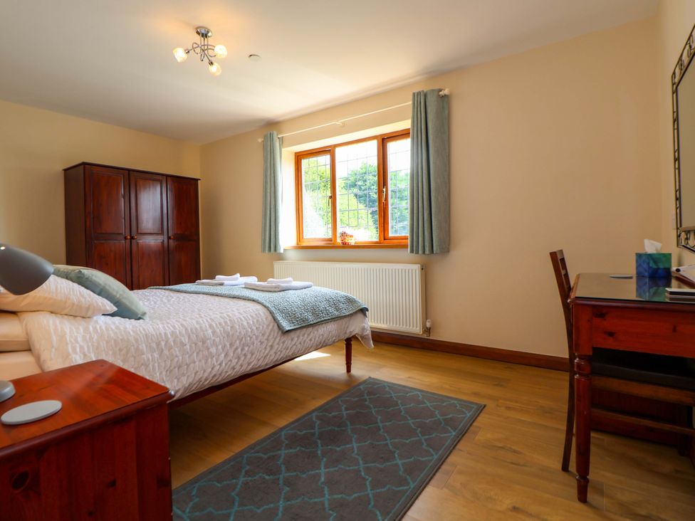 A bedroom with a bed and a wardrobe at The Brambles in Holt, North Wales