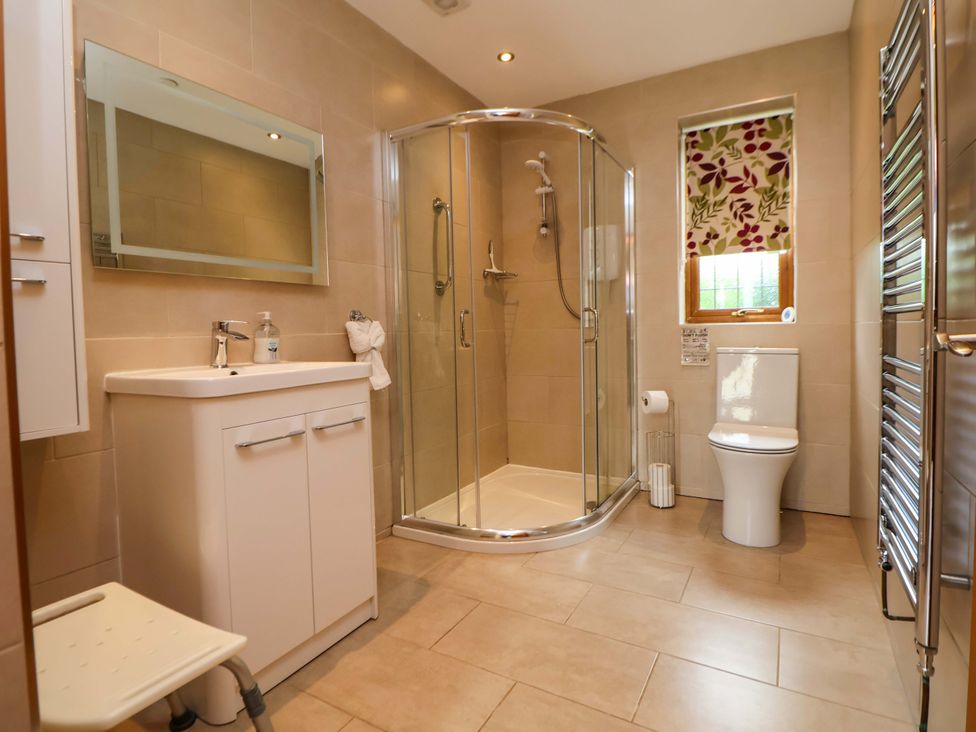 A bathroom with a shower and sink at The Brambles in Holt, North Wales