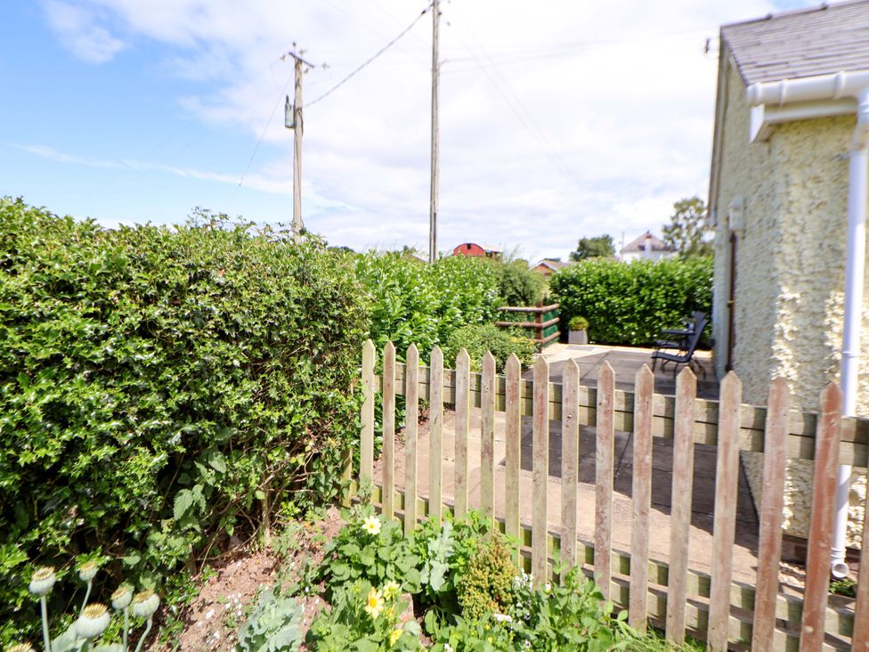 A garden area with a fence and pathway at The Brambles in Holt, North Wales