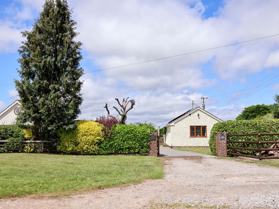 A house surrounded by hedges and trees at The Brambles in Holt, North Wales