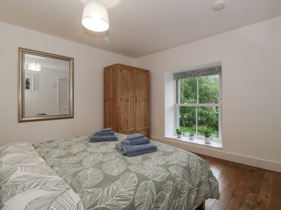A bedroom with a bed and wardrobe at Ty Capel Bethania in Nant Gwynant