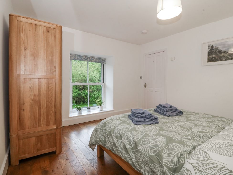 A bedroom with a bed and wardrobe at Ty Capel Bethania Nant Gwynant