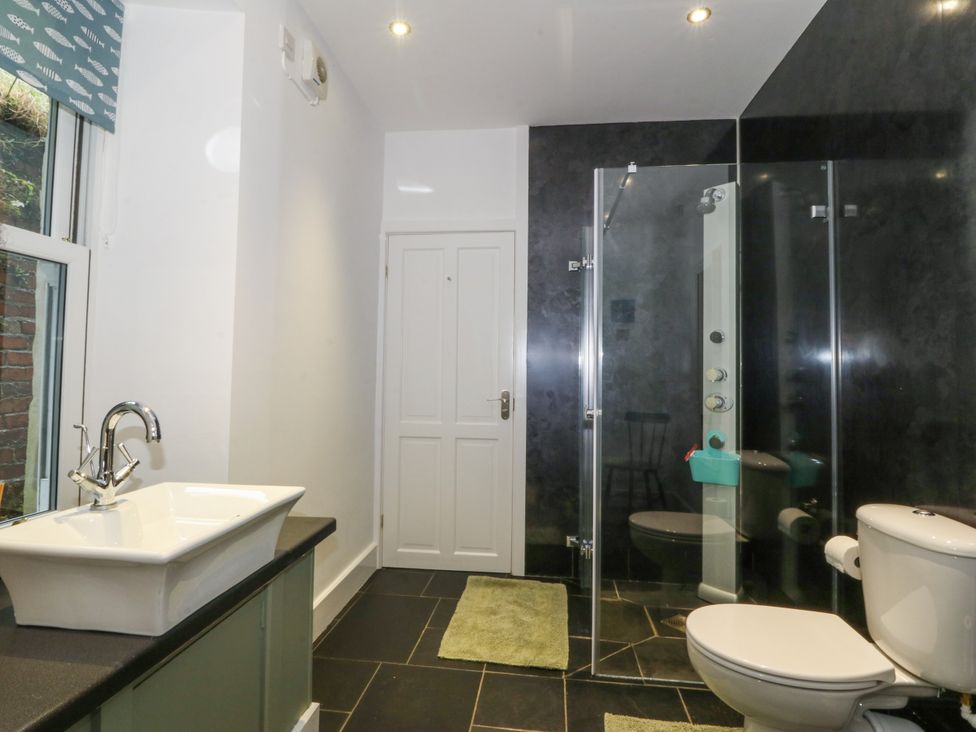 A bathroom featuring a sink, shower, toilet and a window at Ty Capel Bethania, Nant Gwynant