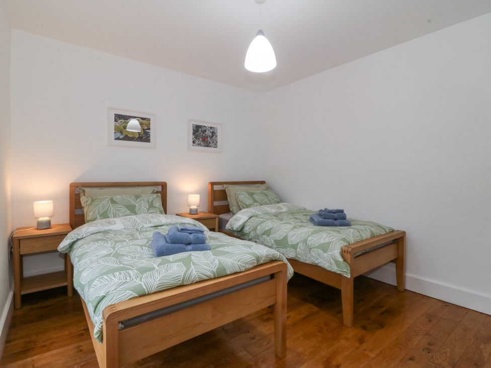 A bedroom with two beds and bedside tables at Ty Capel Bethania Nant Gwynant
