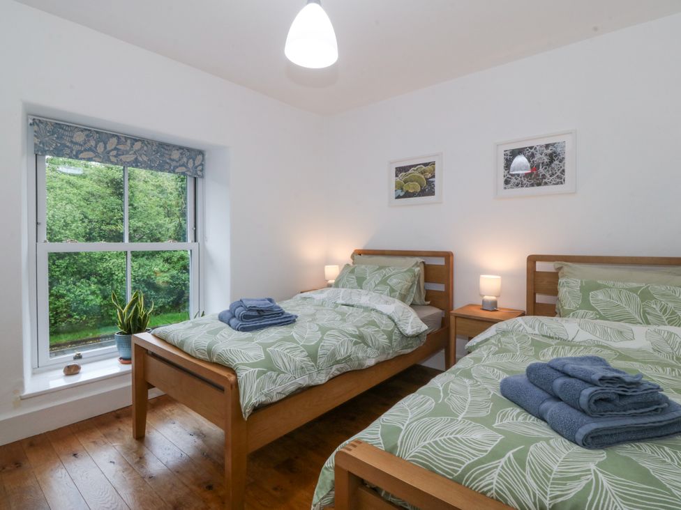 A bedroom with two beds and a window at Ty Capel Bethania Nant Gwynant