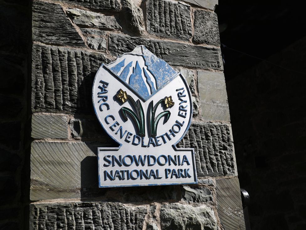 A sign for Snowdonia National Park on a stone wall