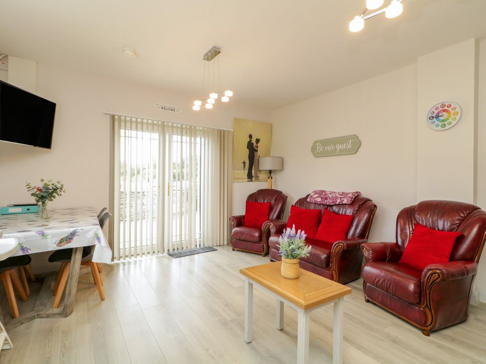 A living room with a sofa and dining area at Duffy Lodge Kilmacloo near Creeslough County Donegal