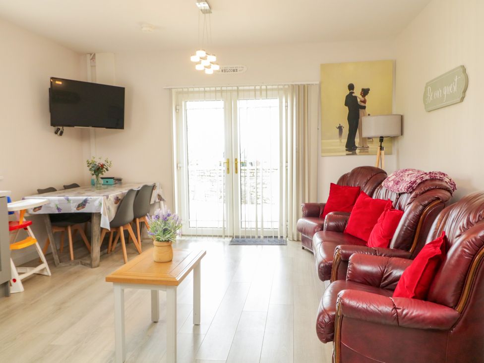 A living room with sofa and television at Duffy Lodge, Kilmacloo near Creeslough, County Donegal