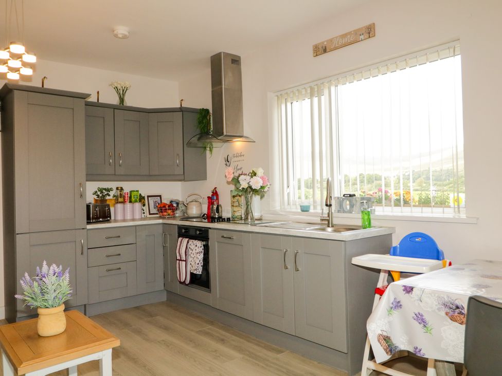 A kitchen with grey cabinets and a table at Duffy Lodge Kilmacloo near Creeslough, County Donegal