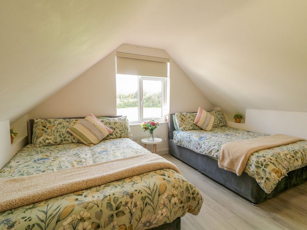 A bedroom with two beds and a window at Duffy Lodge, Kilmacloo near Creeslough, County Donegal