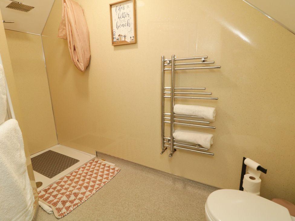 A bathroom with a shower and towel rack at Duffy Lodge Kilmacloo near Creeslough County Donegal