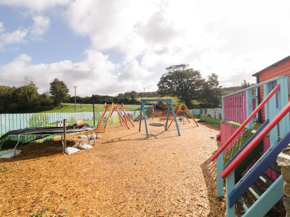 An outdoor play area with a trampoline, swings, and slides at Duffy Lodge Kilmacloo near Creeslough, County Donegal