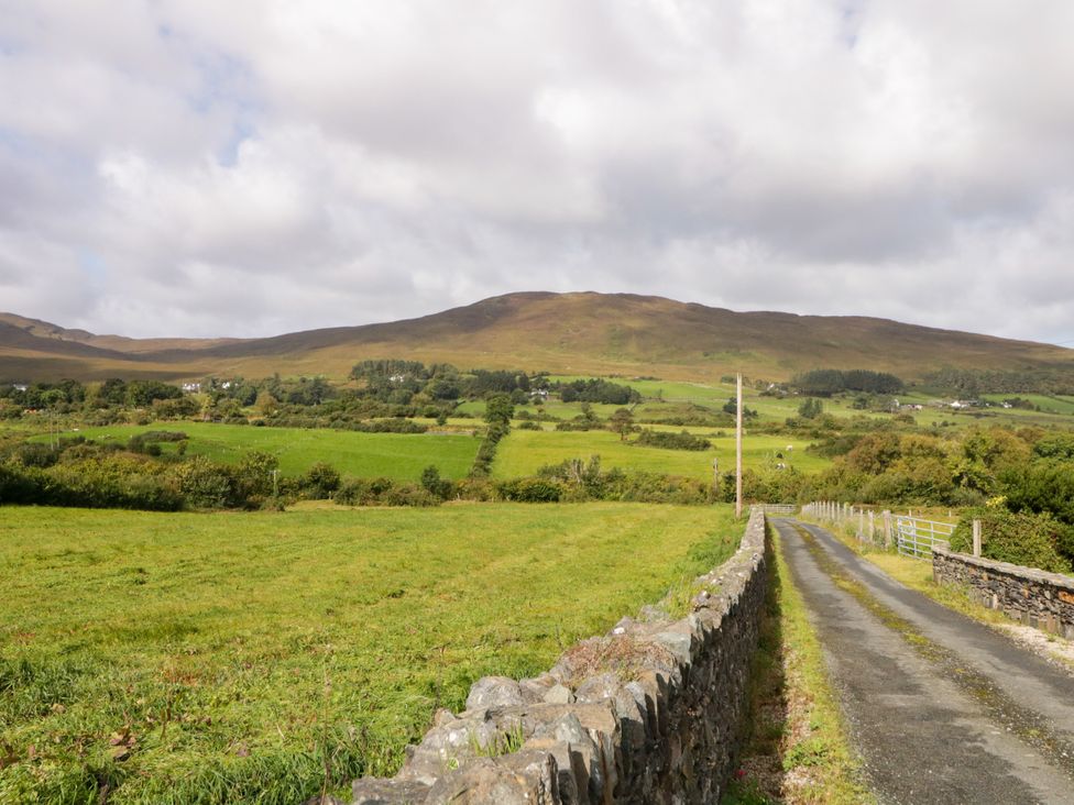 A field with a road leading towards a mountain at Duffy Lodge in Kilmacloo near Creeslough, County Donegal