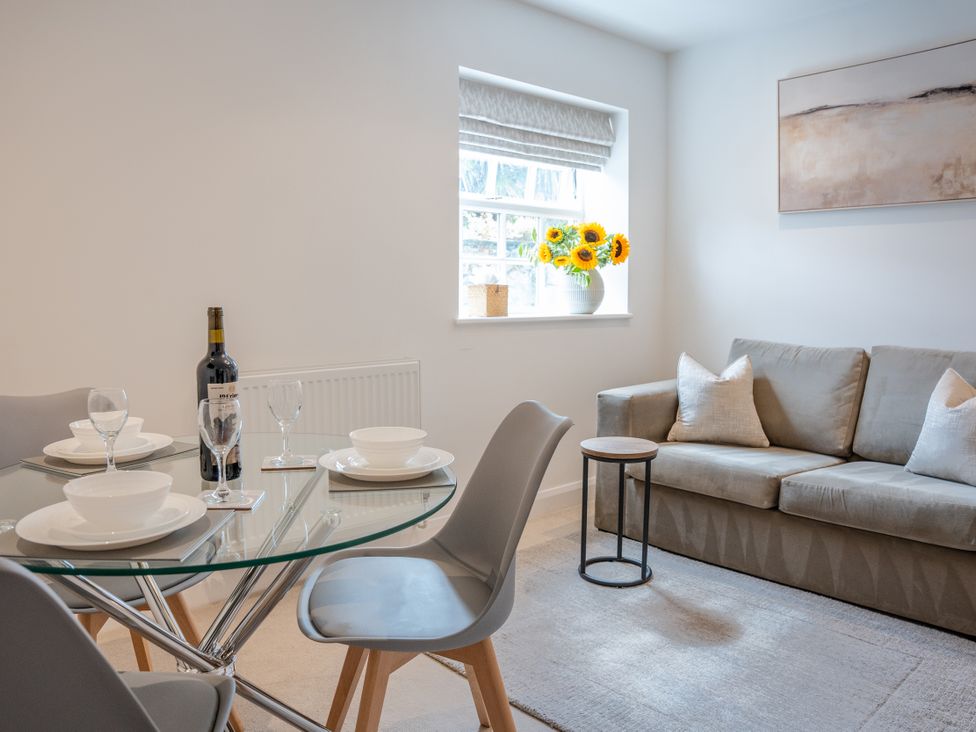 A dining room with a table and couch at Ullswater in Ulverston