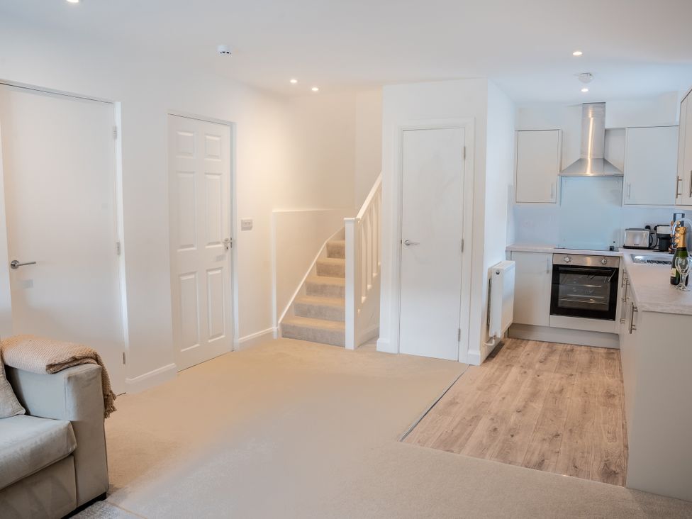 A living room with a staircase and kitchen units at Ullswater in Ulverston